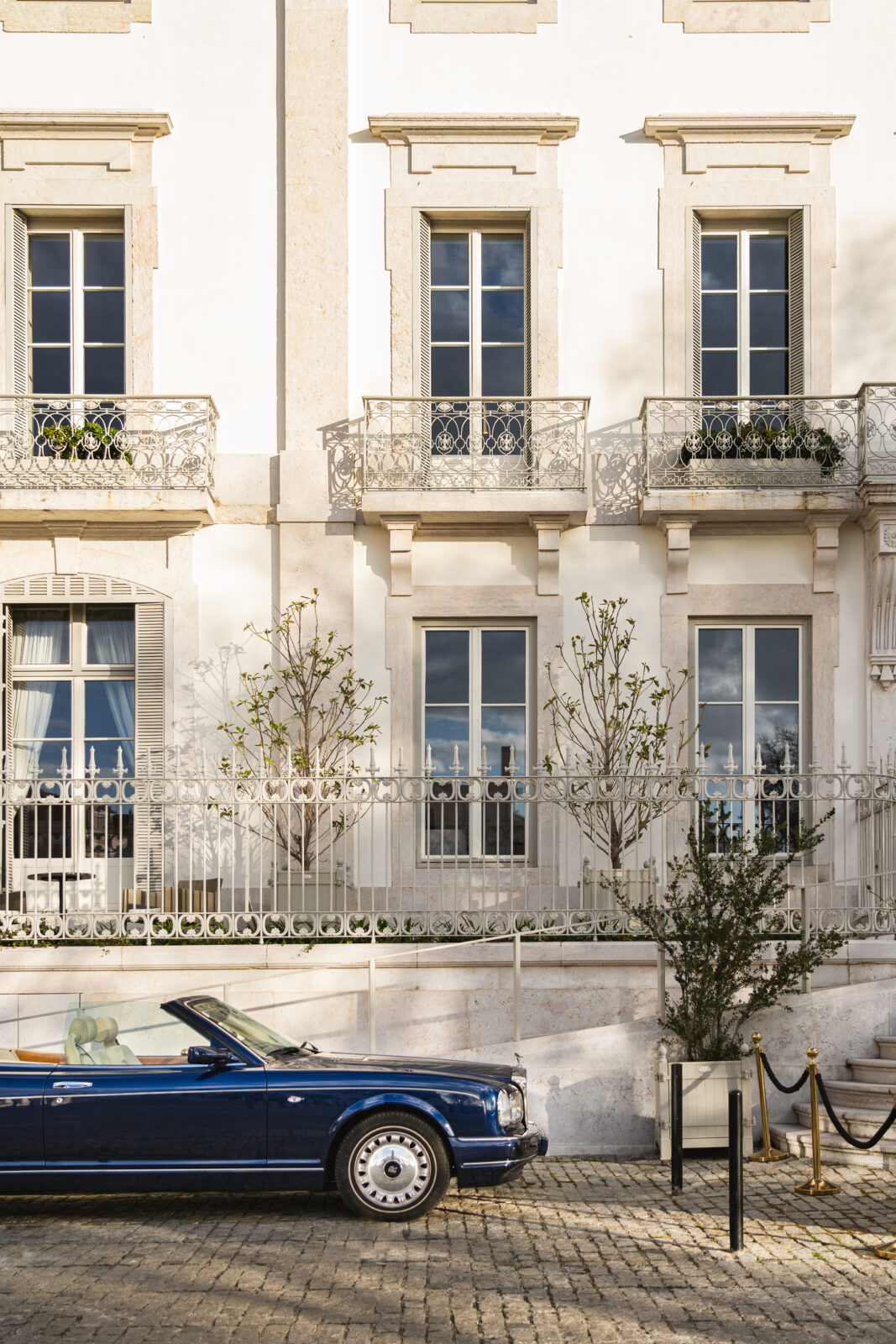 Luxury vintage car parked in front of Verride Santa Catarina historic palace facade in Lisbon